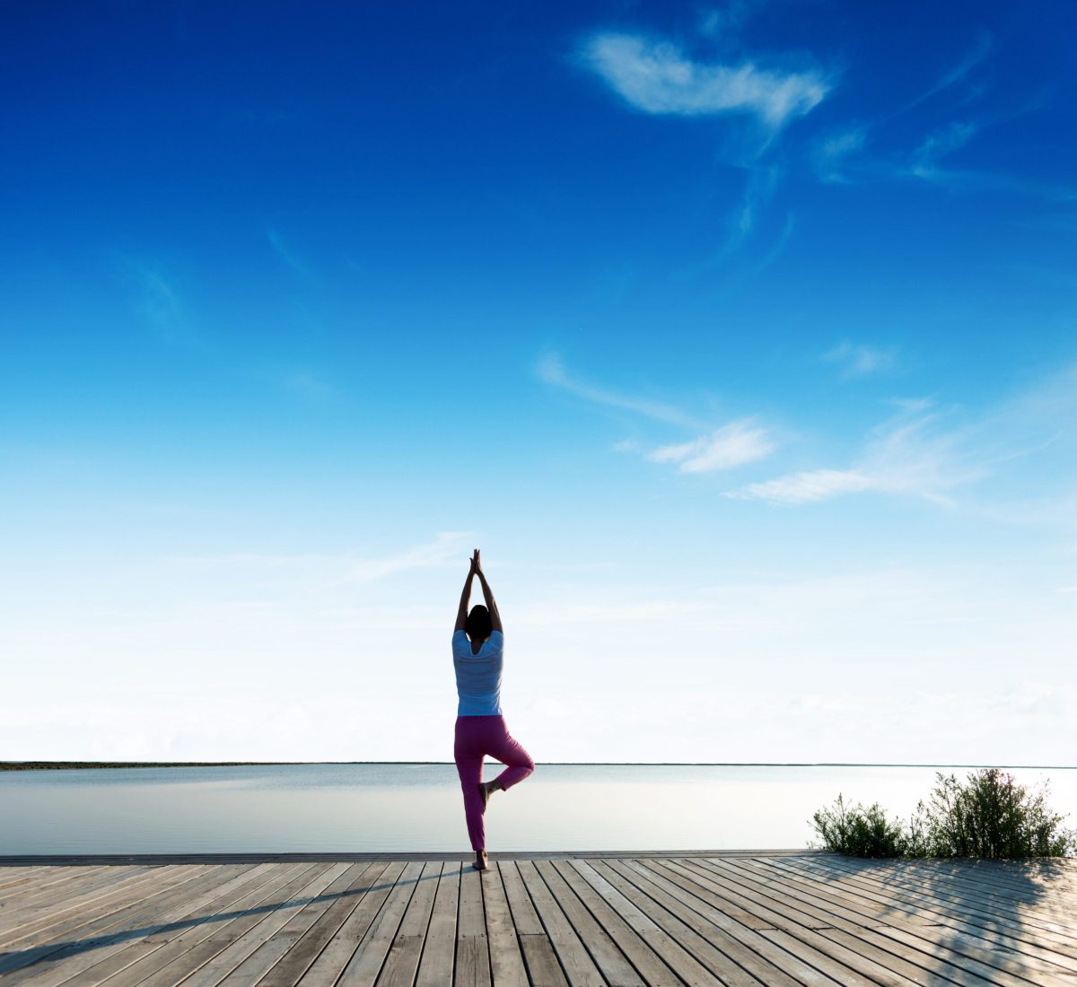 Young woman meditation by the lake.